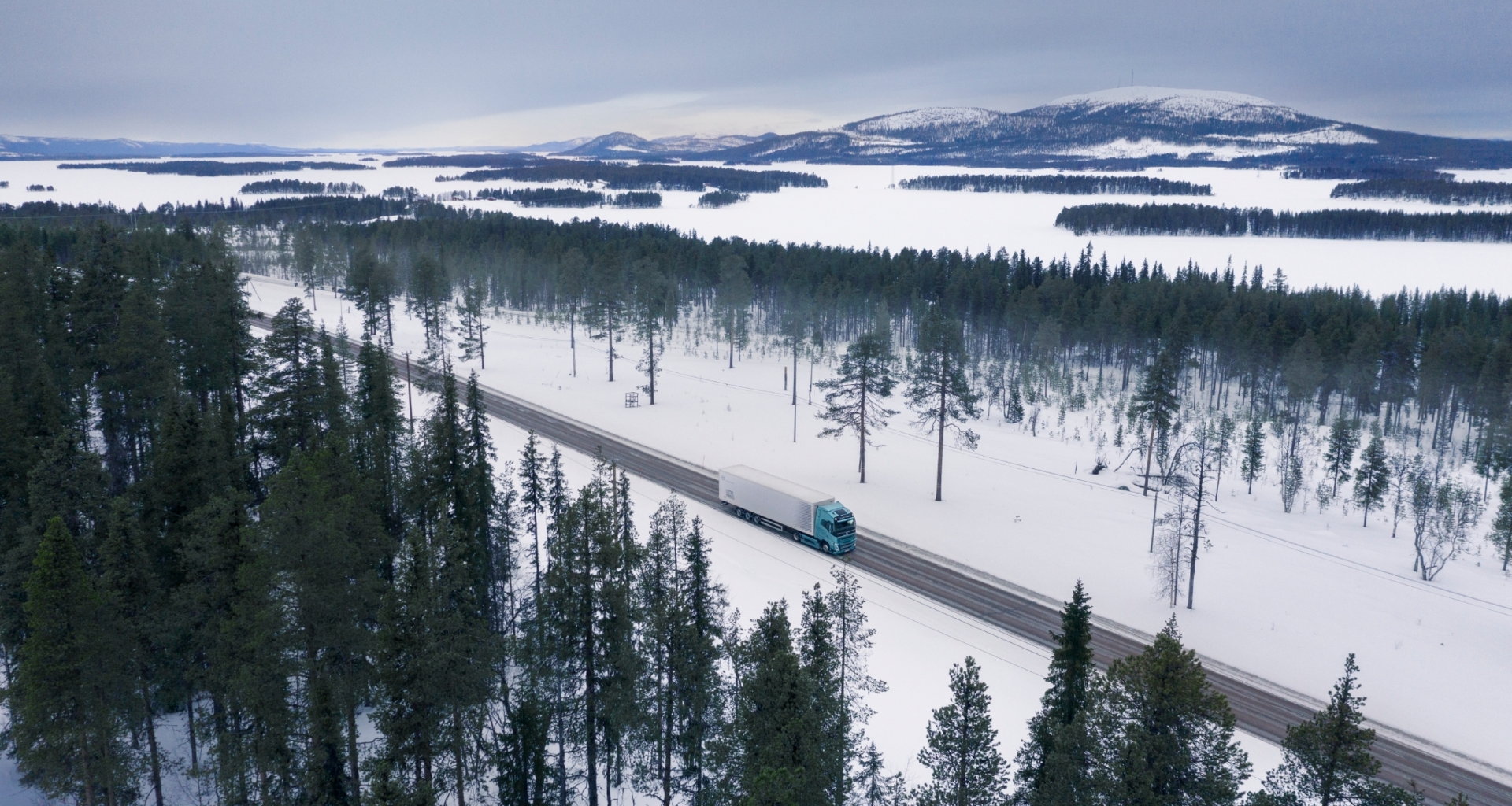 Bluekens-truck-en-bus-Volvo-Electric-rijdend-over-brug-in-sneeuw-landschap